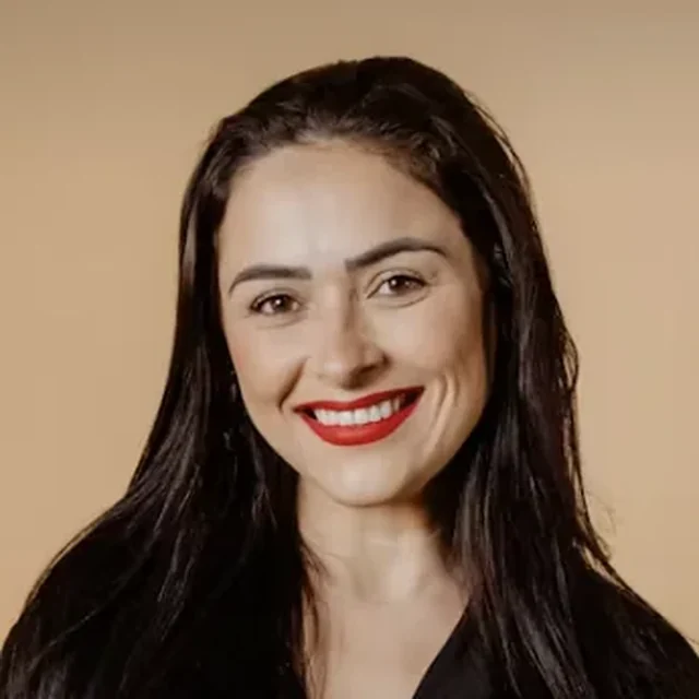 Smiling au pair in a black shirt against a warm neutral background